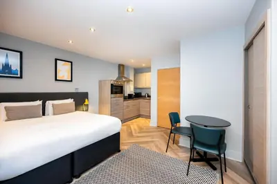 a bedroom with a bed and a table and a kitchen at Staycity Aparthotels Edinburgh West End in Edinburgh