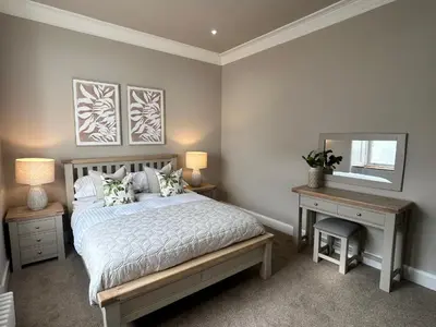 a bedroom with a bed and a desk and a mirror at Crookston Hotel in Glasgow