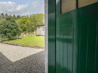 a green garage door with a view of a yard at Drover's Way in Newyork