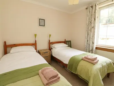 two beds in a room with a window at Drover's Way in Newyork