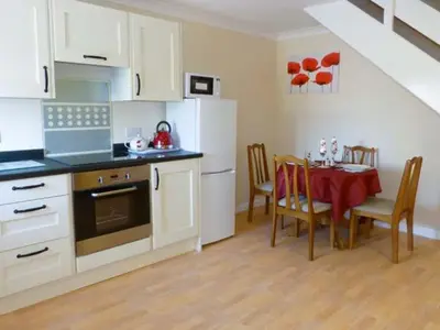 a kitchen with a table and a dining room at Sky Blue Cottage in Forth