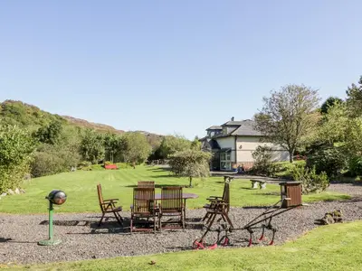 a group of chairs and a table in a park at Glen Euchar House in Kilninver