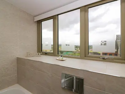 a bathroom with large windows with a view of the city at Muirmailing Cottage in Plean