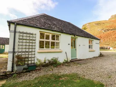a white house with a mountain in the background at Darach in Lunga