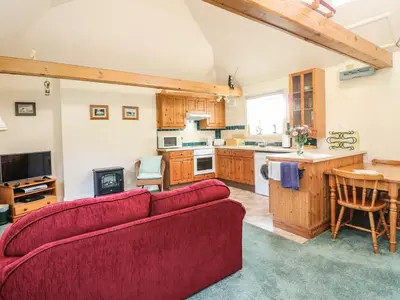 a living room with a red couch and a kitchen at Darach in Lunga