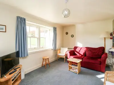 a living room with a red couch and a tv at Mullach in Lunga