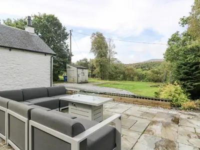 a living room with a couch and a table on a patio at Heatherbank in Garelochhead