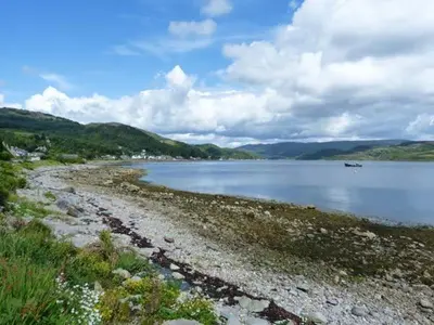 a large body of water with a rocky shore at Top Flat in Tighnabruaich