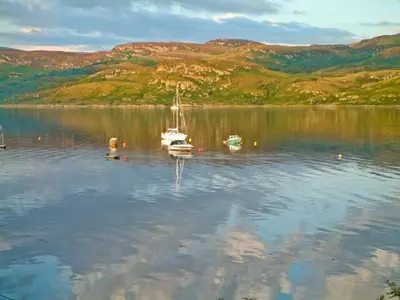 a group of boats sitting on a large body of water at Top Flat in Tighnabruaich