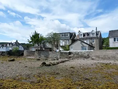 a group of houses in a field with a yard at Top Flat in Tighnabruaich