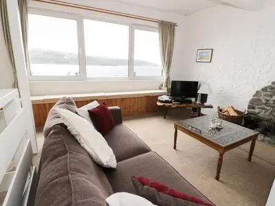 a living room with a couch and a table at Top Flat in Tighnabruaich