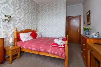 a bedroom with a bed with a red and white blanket at Castle Walk Bed & Breakfast in Stirling