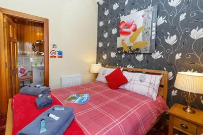 a bedroom with a red bed with a red blanket at Castle Walk Bed & Breakfast in Stirling