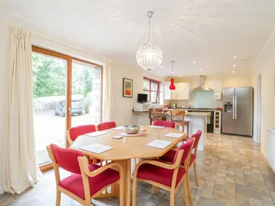 a kitchen and dining room with a table and chairs at Woodland Villa in Oban