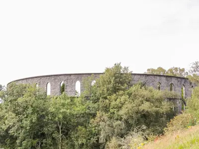 an old brick building on the side of a hill at Woodland Villa in Oban