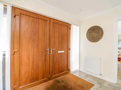 a large wooden cabinet in a room with a window at Woodland Villa in Oban