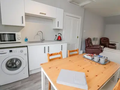 a kitchen with a table and a sink and a microwave at The Knowe Upper in Taynuilt