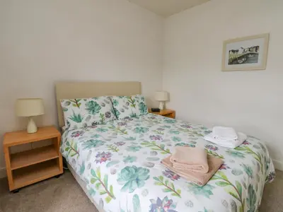 a bedroom with a bed and two night stands at The Knowe Upper in Taynuilt