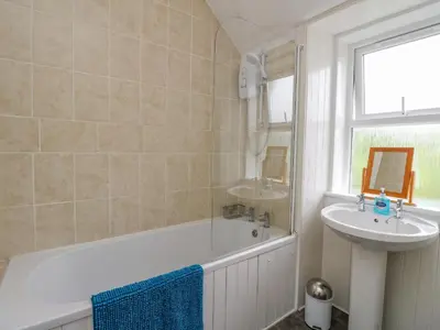 a bathroom with a bath tub and a sink at The Knowe Upper in Taynuilt