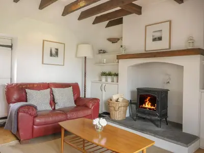 a living room with a couch and a fireplace at Sweetpea Cottage in Wiston