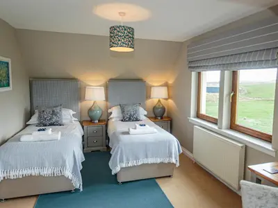 two beds in a room with two windows at Corsewall Castle Farm Lodges in Kirkcolm