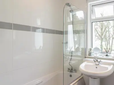 a white bathroom with a sink and a shower at Pebble Nook in Onich