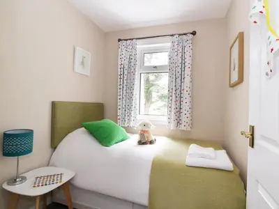 a small bedroom with a bed and a window at Pebble Nook in Onich