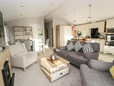 a living room with a couch and a table at Woodstock Lodge in Skelmorlie