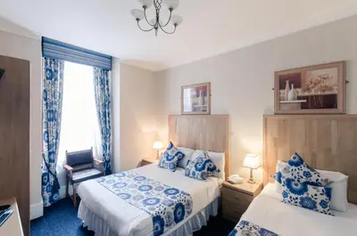 a hotel room with two beds and a window at Argyll Guest House in Glasgow
