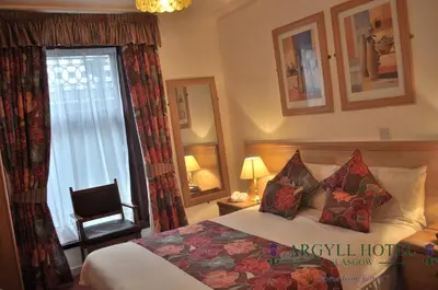 a hotel room with a bed and a window at Argyll Guest House in Glasgow