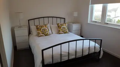 a bedroom with a bed with pillows and a window at Flemming Place in East Kilbride