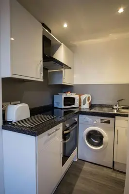 a kitchen with a washing machine and a sink at Stylish City Apartment - Near Haymarket, Walk to Castle and Princes Street in Edinburgh