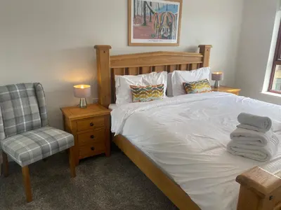 a bedroom with a bed with a chair and a desk at Central West End City Apartment in Glasgow