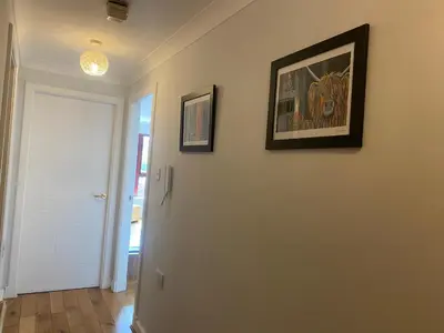 a hallway with two framed pictures on a wall at Central West End City Apartment in Glasgow
