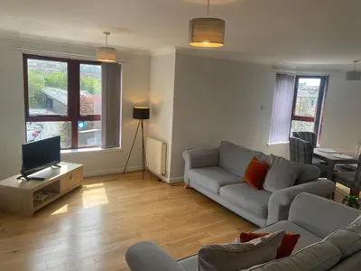 a living room with a couch and a tv at Central West End City Apartment in Glasgow