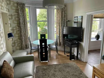 a living room with a couch and a tv and a table at Scotstoun 1 Bed Flat in Glasgow