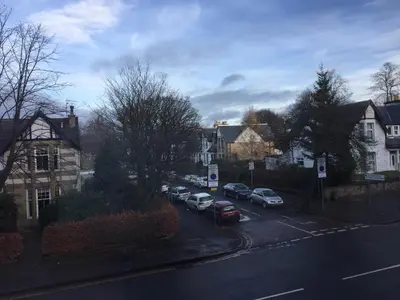 a street with cars parked in a residential neighborhood at Scotstoun 1 Bed Flat in Glasgow