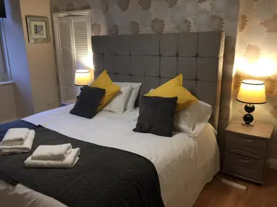 a bedroom with a large bed with yellow pillows at Scotstoun 1 Bed Flat in Glasgow