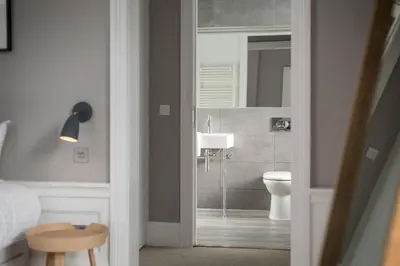 a bathroom with a sink and a toilet and a mirror at JOIVY Spacious Apartment close to Princes Street in Edinburgh