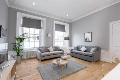 a living room with two couches and a table at JOIVY Spacious Apartment close to Princes Street in Edinburgh