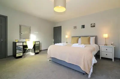 a bedroom with a large bed in a room at Signature - Burnbank House in Hamilton