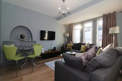 a living room with a couch and a table at Signature - Burnbank House in Hamilton
