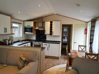 a kitchen and living room with a couch and a table at Shanthi Lodge in Dunning