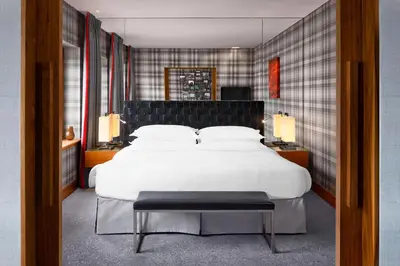 a bedroom with a large white bed and two lamps at Sheraton Grand Hotel & Spa in Edinburgh