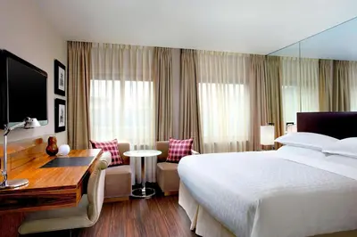 a hotel room with a large bed and a desk at Sheraton Grand Hotel & Spa in Edinburgh