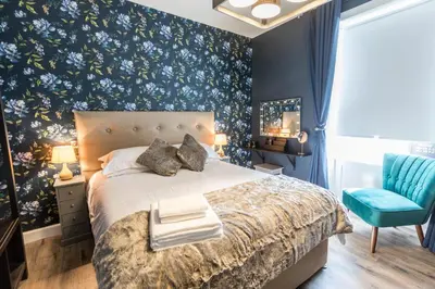 a bedroom with a bed with blue floral wallpaper at The Torfin in Edinburgh