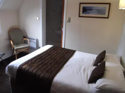 a hotel room with a bed and a chair at Arrochar Hotel 'A Bespoke Hotel' in Arrochar