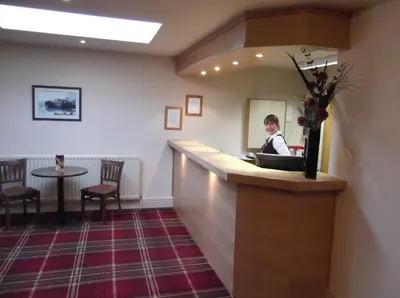a woman sitting at a bar in a waiting room at Arrochar Hotel 'A Bespoke Hotel' in Arrochar