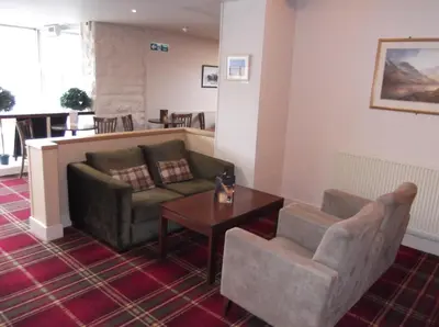 a living room with a couch and a table and chairs at Arrochar Hotel 'A Bespoke Hotel' in Arrochar