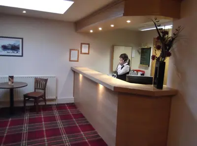 a woman talking on a phone at a bar at Arrochar Hotel 'A Bespoke Hotel' in Arrochar